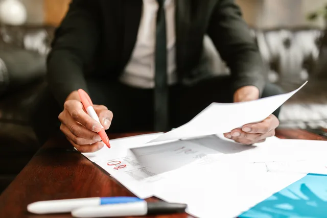 Businessman working with financial documents at office desk, highlighting details. What affects commercial coverage premiums