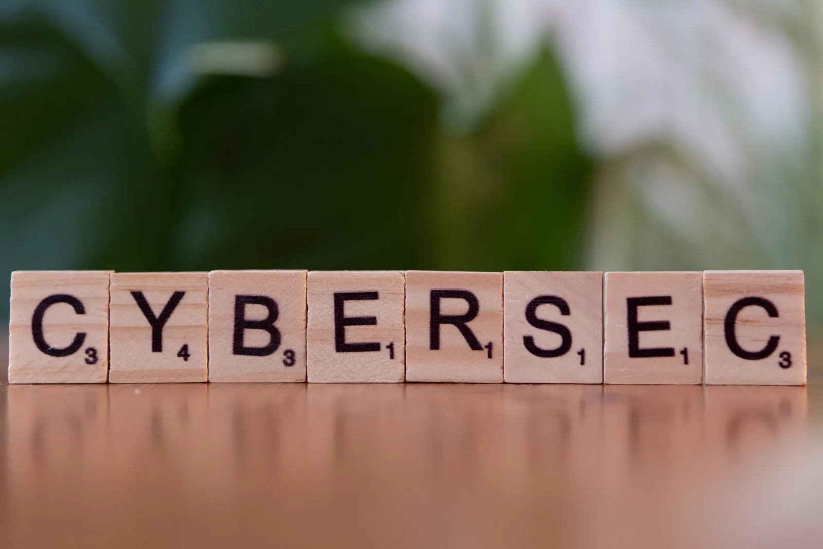 Wooden tiles spell 'CYBERSEC' against a soft-focused green background. Cyber insurance cost for small business: five inputs that move the premium