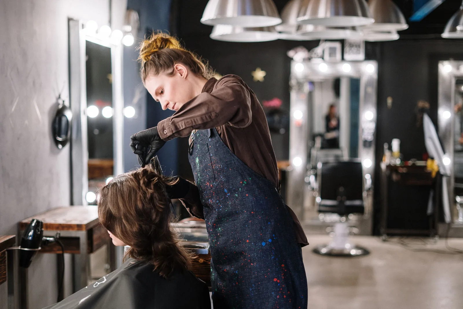 A female stylist expertly applying hair color to a client in a modern salon setting. Cyber insurance for booth renters Ontario: what it covers